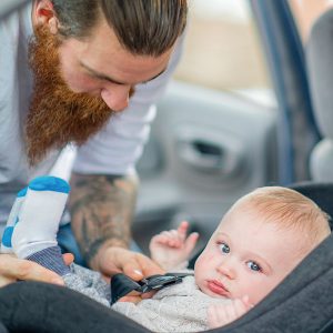 Father securing his baby in a car seat